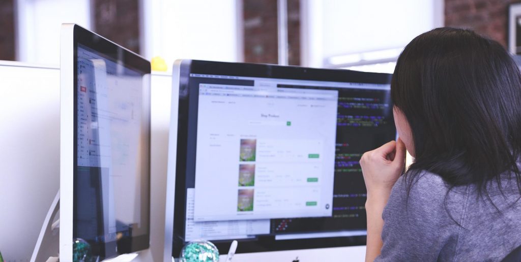 Woman performing nearshore software development services through coding