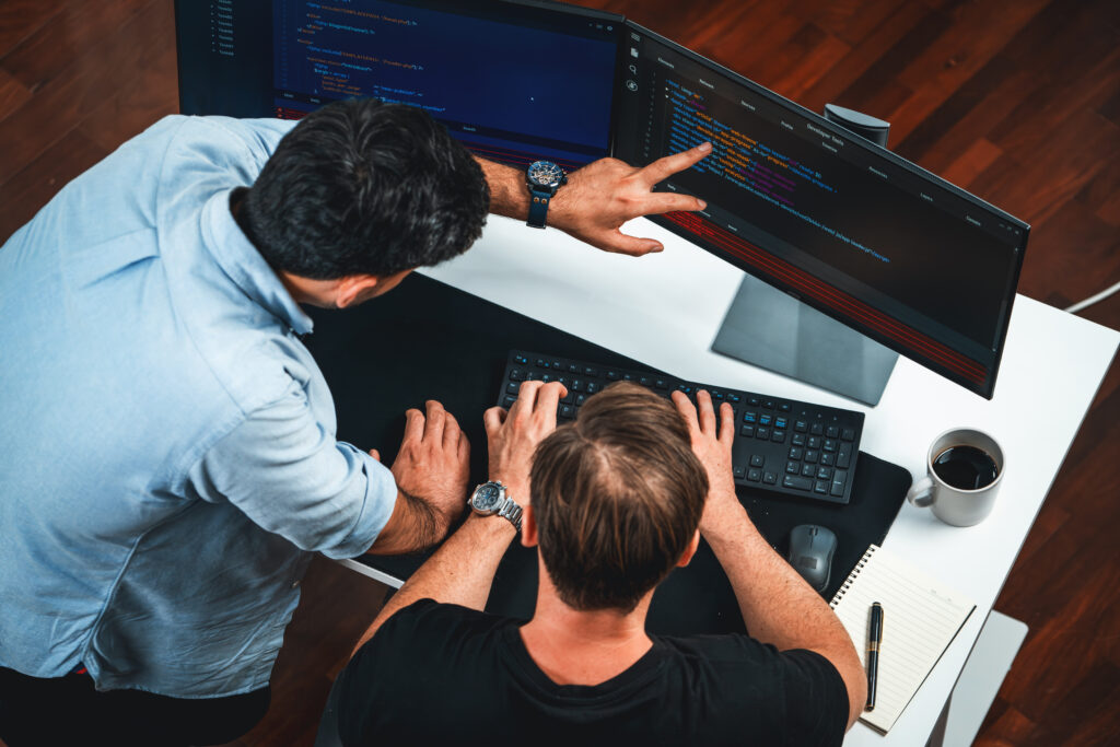 IT developers discussing online software development information on pc screen, creating program coding for latest version application on website. Concept of brainstorming firmware updated. Sellable.
